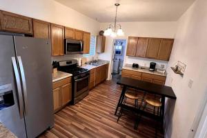a kitchen with a refrigerator and a table in it at The Heart Of Cruces in Las Cruces