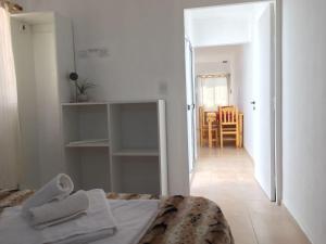 a white bedroom with a bed and a hallway at Brisas de San Rafael in San Rafael