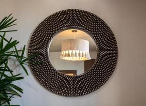 a round mirror hanging on a wall with a lamp at Hotel Scappata in Progreso