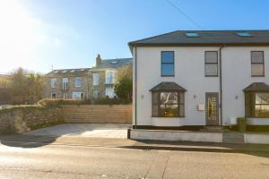 una casa blanca con una puerta amarilla en una calle en Nova Cottage en St Ives