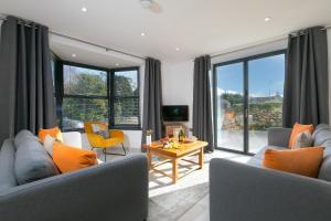 a living room with two couches and a table at Nova Cottage in St Ives