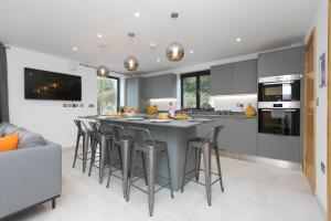 a kitchen with a large gray island with bar stools at Nova Cottage in St Ives