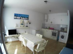 a room with a table and a kitchen with a table and chairs at CasaMandy CotilloMar in Cotillo