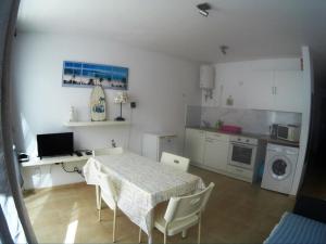 a room with a table and a kitchen with a table and chairs at CasaMandy CotilloMar in El Cotillo