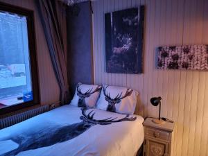 a bedroom with a bed with a deer on the pillows at RESIDENCE BELLE HUTTE COTÉ PISTES DE SKI 2 in La Bresse