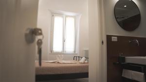 a bathroom with a bed with a window and a mirror at Corso Italia Pisa Smart Rooms in Pisa