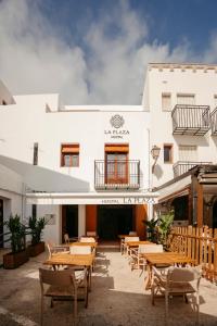 a restaurant with tables and chairs in front of a building at La Plaza Hostal in Peñíscola