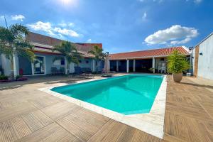 une piscine devant une maison dans l'établissement Chacara c Wi-Fi, piscina e churrasqueira em Itu SP, à Itu