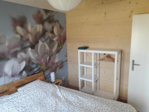 a bedroom with a bed and a wall with a flower mural at Chalet - Le Champ des Perches, Berlincourt in Glovelier