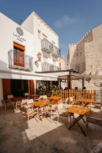 a group of tables and chairs in front of a building at La Plaza Hostal in Peñíscola