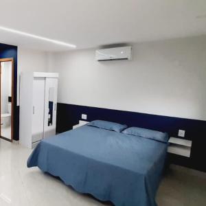 1 dormitorio con cama azul y manta azul en FLAT 22º andar totalmente mobiliado lazer completo, en Guarulhos