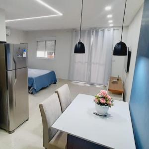 Zimmer mit einem Tisch und einer Küche mit einem Kühlschrank. in der Unterkunft FLAT 22º andar totalmente mobiliado lazer completo in Guarulhos