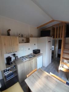 una pequeña cocina con mesa de madera y mesa de madera en Maison Tiny House 2 chambres Soulac a 500m plage, en Soulac-sur-Mer