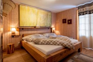 una camera con un letto in una stanza con pareti in legno di Chalet Bijou a Blitzingen