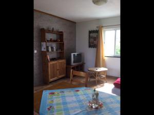 sala de estar con mesa y TV en Sunshine House no.2, en Madalena