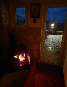 a fireplace in a room with a view of a yard at Vikendica,Bungalovi Lipska pećina in Cetinje