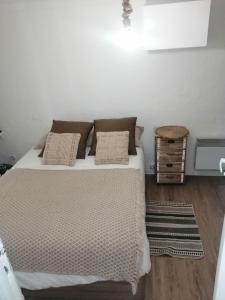 Un dormitorio con una cama con almohadas. en appartement cosy situé à 2mn de la plage à pied climatise, en Villefranche-sur-Mer