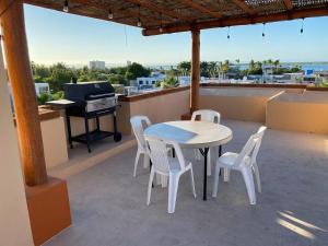 a table and chairs on a roof with a piano at Hermoso edificio ubicado a pocas cuadras del Malecón de La Paz BCS in La Paz