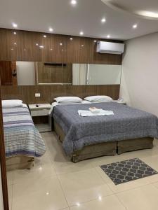 a bedroom with two beds and a mirror at Prudentópolis Palace Hotel in Prudentópolis