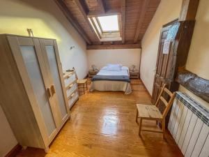 1 dormitorio con 1 cama y suelo de madera en Casa Berrobiaenea, en Narcué