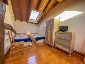 a bedroom with two beds and a television in it at Casa Berrobiaenea in Narcué