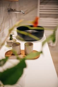 a counter top with two cups and a sink at Chambres d'hôtes Eucalyptus et Glycine in Genval