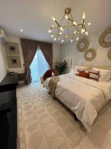 een grote slaapkamer met een groot bed en een kroonluchter bij Exquisite Apt @ Lennox Airport. in Accra