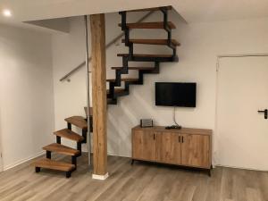a living room with a staircase and a tv at Ruhige Nachbarschaft in Hamminkeln