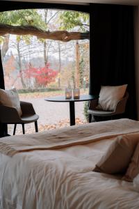 1 dormitorio con cama, mesa y ventana en Chambres d'hôtes Eucalyptus et Glycine en Genval