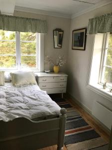 a bedroom with a bed and two windows at Nedre Skogtun cabin by Norgesbooking in Hovda