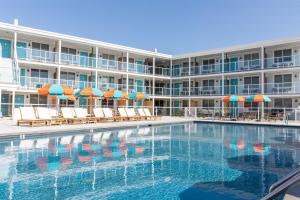 a hotel with a swimming pool with chairs and umbrellas at Beach Shack in Cape May