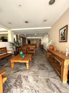 a lobby with wooden benches and tables at Hotel Thermas da Mantiqueira - Poços de Caldas - De frente para a Praça Central in Poços de Caldas +36 photos