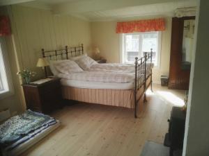 Un dormitorio con una cama grande y una ventana en Nedre Skogtun cabin by Norgesbooking, en Hovda