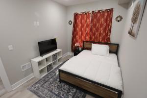 um quarto com uma cama e uma televisão de ecrã plano em The Close Temple University em Filadélfia