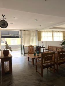 a living room with wooden furniture and a clock on the wall at Thermas da Mantiqueira Hotel in Poços de Caldas
