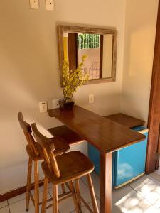 una mesa de madera con 2 sillas y un espejo en Pousada Portal Sul, en Florianópolis