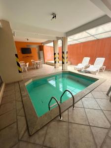 a pool in a hotel room with chairs and tables at Thermas da Mantiqueira Hotel in Poços de Caldas