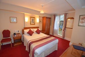um quarto de hotel com uma cama e uma janela em Parkwood Hotel em Londres