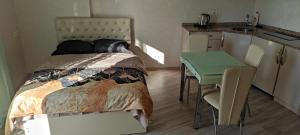 ein Schlafzimmer mit einem Bett und einem Tisch sowie eine Küche in der Unterkunft Apartment Orbi Plaza in Batumi