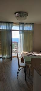 uma sala de jantar com uma mesa e vista para o oceano em Apartment Orbi Plaza em Batumi
