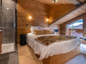 um quarto com uma cama grande num quarto de madeira em Appartement Les Allues-Méribel, 3 pièces, 6 personnes - FR-1-355-213 em Les Allues