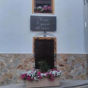 een bord aan de zijkant van een gebouw met bloemen bij Casa Capricho del Destino 