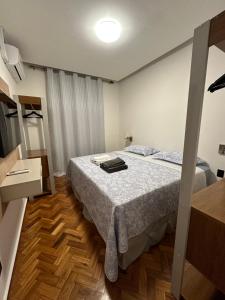 1 dormitorio con 1 cama y suelo de madera en Belíssimo apartamento com vista para a praia de Copacabana e cristo, en Río de Janeiro