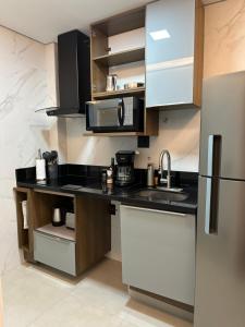 a kitchen with a sink and a refrigerator at Belíssimo apartamento com vista para a praia de Copacabana e cristo in Rio de Janeiro