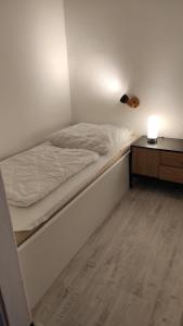 um quarto com uma cama e uma mesa de cabeceira com um candeeiro em Harz Stube em Goslar