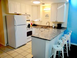 uma cozinha com um frigorífico branco e armários brancos em A Wave From It All-5J GCR em Myrtle Beach