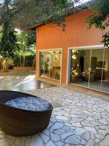 a building with a stone patio with a bench in front of it at ossos paradise in Búzios