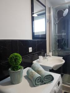 a bathroom with a sink and towels on a counter at APARTMAN PARK in Šabac