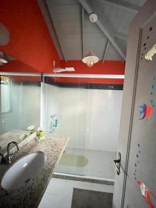 a bathroom with a shower and a sink and a tub at ossos paradise in Búzios