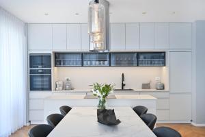 a kitchen with white cabinets and a table and chairs at Silk & Silver by HolyGuest in Tel Aviv